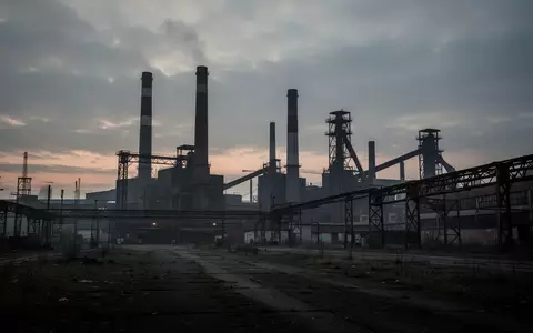 Ein weites, stilles Industriegelände mit Fabrikschornsteinen und Stahlbauten in Sachsen bei Dämmerung. - Foto: über boerse-global.de