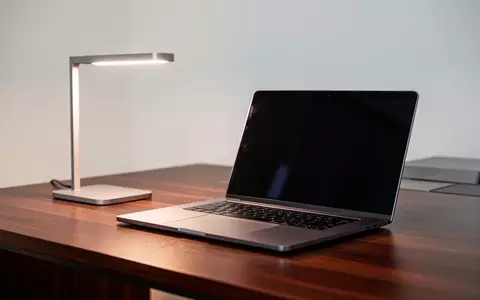 Ein moderner, aufgeräumter Schreibtisch mit einem zugeklappten Laptop und einer Schreibtischlampe in natürlichem Licht. - Foto: über boerse-global.de