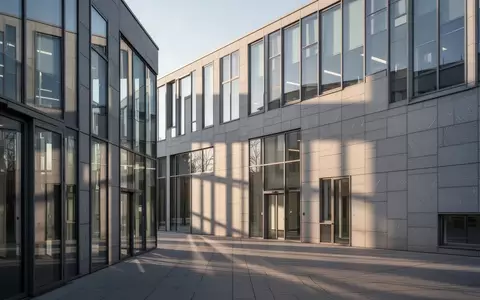 Moderne Fassade eines hessischen Verwaltungsgebäudes in klarem Tageslicht mit geometrischen Schattenwürfen. - Foto: über boerse-global.de