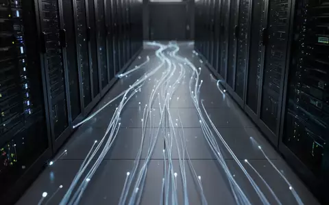 Ein dunkler Serverraum mit leuchtenden Glasfaserkabeln, die digitale Sicherheitsinfrastruktur symbolisieren. - Foto: über boerse-global.de