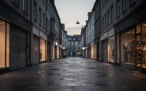 Leere Einkaufsstraße in einer deutschen Stadt mit geschlossenen Ladenfronten und gedimmter Beleuchtung bei Dämmerung. - Foto: über boerse-global.de