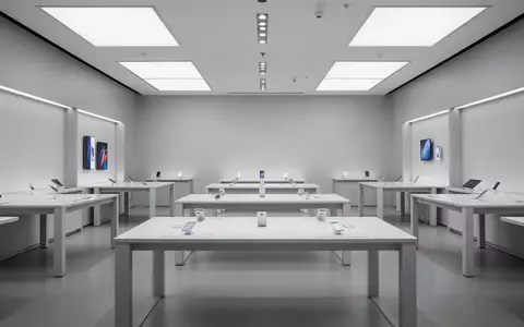Ein minimalistischer, leerer Verkaufsraum eines Elektronikgeschäfts mit weißen Tischen und indirekter Beleuchtung. - Foto: über boerse-global.de