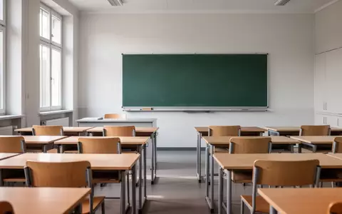 Ein leerer, modern eingerichteter Klassenraum mit Holztischen und einer leeren Schultafel in einer hessischen Schule. - Foto: über boerse-global.de
