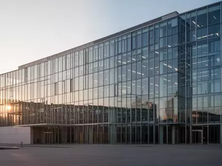 Ein modernes Bürogebäude aus Glas und Stahl in Berlin bei Sonnenaufgang, das als Sitz für staatliche Institutionen dient. - Foto: über boerse-global.de
