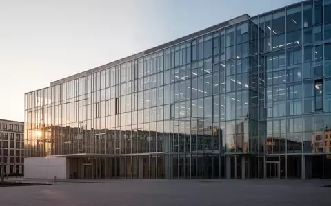 Ein modernes Bürogebäude aus Glas und Stahl in Berlin bei Sonnenaufgang, das als Sitz für staatliche Institutionen dient. - Foto: über boerse-global.de