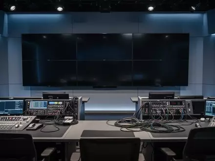 Ein modernes, unbesetztes Broadcast-Studio mit professionellen Monitoren und Mischpulten in einer Produktionsumgebung. - Foto: über boerse-global.de