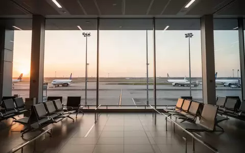 Moderner, leerer Flughafen-Abflugbereich bei Sonnenaufgang mit Blick auf das Rollfeld. - Foto: über boerse-global.de