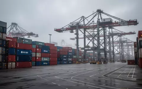 Leeres Containerterminal im Hamburger Hafen mit stillstehenden Verladekränen unter bewölktem Himmel. - Foto: über boerse-global.de