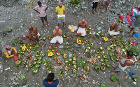 Menschen, deren Angehörige nach den Sturzfluten weiterhin vermisst werden, vollziehen am Ufer des angeschwollenen Trishuli-Flusses im nepalesischen Distrikt Nuwakot Rituale im Anschluss an symbolische Bestattungszeremonien. - Foto: Rajesh Kumar Singh/AP/dpa