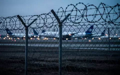 Ein Sicherheitszaun am Rande eines Frachtflughafens in der Morgendämmerung. - Foto: über boerse-global.de