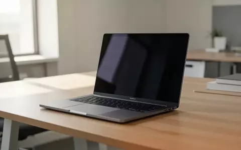 Ein modernes, geschlossenes Arm-basiertes Laptop auf einem minimalistischen Schreibtisch in einem hellen Büro. - Foto: über boerse-global.de