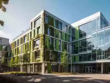 Modernes Schulgebäude in einer Stadt mit begrünten Fassadenelementen zur Hitzereduktion an einem sonnigen Tag. - Foto: über boerse-global.de
