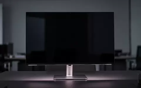 Ein moderner, ausgeschalteter High-End-Monitor auf einem minimalistischen Schreibtisch in einem dunklen Studio. - Foto: über boerse-global.de