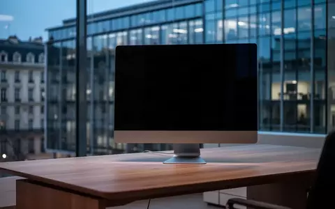 Ein dunkler, moderner Büroarbeitsplatz mit einem ausgeschalteten Computerbildschirm vor einer gläsernen Fassade. - Foto: über boerse-global.de