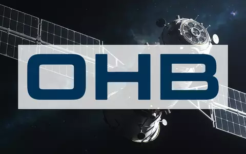 Ein hochmoderner Satellit schwebt im tiefen Weltraum vor einem atmosphärischen kosmischen Hintergrund. - Foto: über boerse-global.de