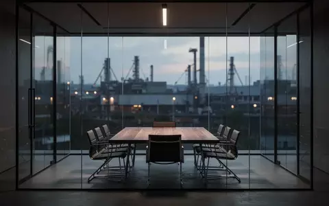 Ein leeres, modernes Büro mit Glaswänden und Blick auf eine Industrieanlage, das die Diskrepanz zwischen Unternehmensanspruch und gelebter Kultur symbolisiert. - Foto: über boerse-global.de