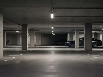 Ein leerer Firmenparkplatz in einer Tiefgarage mit einem dezent im Hintergrund geparkten Dienstwagen. - Foto: über boerse-global.de