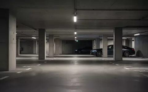 Ein leerer Firmenparkplatz in einer Tiefgarage mit einem dezent im Hintergrund geparkten Dienstwagen. - Foto: über boerse-global.de