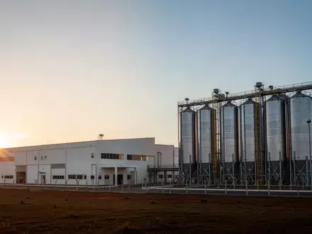 Moderne Industrieanlage in Brasilien bei Sonnenaufgang mit großen Silos vor weitem Himmel. - Foto: über boerse-global.de