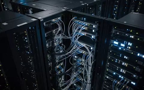 Dunkler Serverraum mit leuchtenden LED-Statusanzeigen an Netzwerkschränken als Symbol für digitale Zahlungsinfrastruktur. - Foto: über boerse-global.de