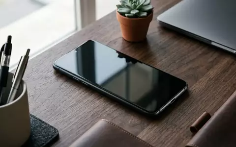 Ein modernes Android-Smartphone mit gesperrtem Bildschirm liegt auf einem dunklen Holztisch. - Foto: über boerse-global.de