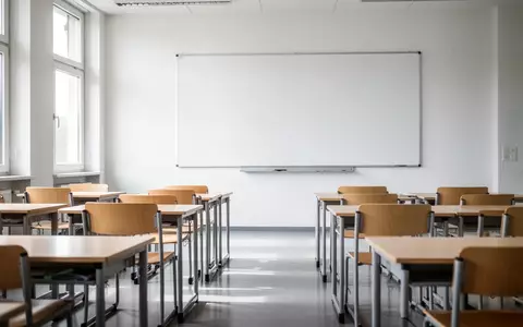 Ein leerer, modern gestalteter Klassenraum mit hellen Holzmöbeln und einer leeren weißen Tafel bei Tageslicht. - Foto: über boerse-global.de