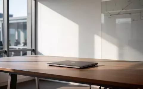 Minimalistischer Büroarbeitsplatz mit geschlossenem Laptop und natürlichem Lichteinfall in einem modernen Gebäude. - Foto: über boerse-global.de