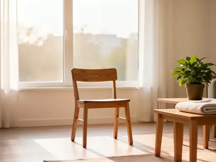 Ein heller, minimalistischer Wohnraum mit einem leeren Stuhl und einer Pflanze, der eine ruhige und gesundheitsfördernde Atmosphäre ausstrahlt. - Foto: über boerse-global.de