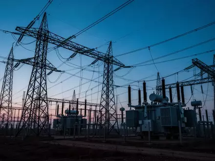 Ein Umspannwerk mit Hochspannungsmasten und Transformatoren in der Dämmerung. - Foto: über boerse-global.de