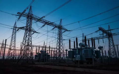 Ein Umspannwerk mit Hochspannungsmasten und Transformatoren in der Dämmerung. - Foto: über boerse-global.de