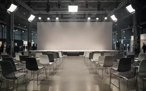 Ein minimalistischer, leerer Veranstaltungsraum auf einer Messe in Berlin mit moderner Architektur und indirekter Beleuchtung. - Foto: über boerse-global.de