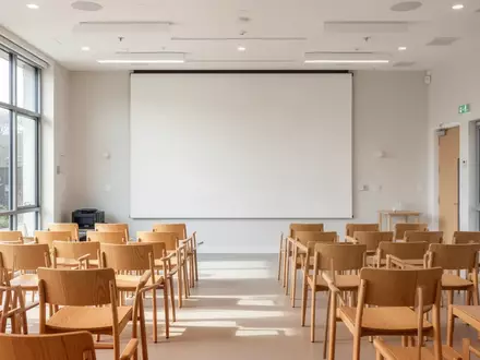 Ein heller, moderner Gemeinschaftsraum mit leeren Stühlen in einem Bildungszentrum, der eine Atmosphäre für Lernangebote schafft. - Foto: über boerse-global.de