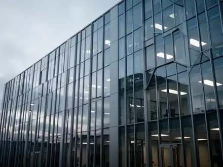Modernes Bürogebäude bei bewölktem Himmel als Symbol für IT-Infrastruktur und Software-Herausforderungen. - Foto: über boerse-global.de
