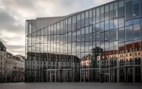 Moderne Glasfassade eines Bürogebäudes in Berlin vor einem bewölkten Himmel. - Foto: über boerse-global.de