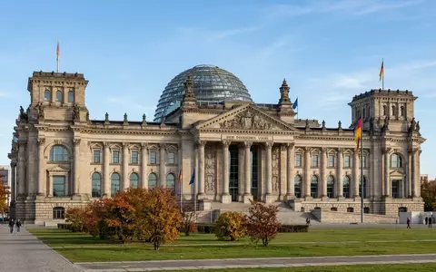 Das Berliner Reichstagsgebäude bei Tageslicht, fokussiert auf die architektonische Fassade und die Glaskuppel. - Foto: über boerse-global.de