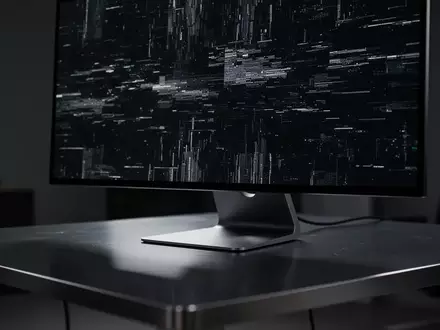 Ein dunkler, moderner Arbeitsplatz mit einem Monitor, der ein digitales Störungsmuster zeigt, symbolisch für Cyberkriminalität. - Foto: über boerse-global.de