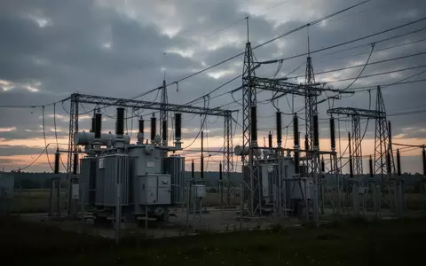 Ein Umspannwerk mit Hochspannungsmasten und Transformatoren bei Dämmerung in einer weitläufigen Landschaft. - Foto: über boerse-global.de