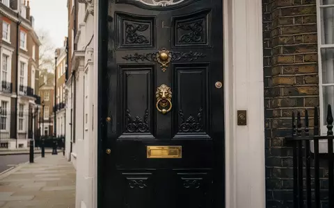 Ein historisches Londoner Stadthaus mit einer charakteristischen schwarzen Eingangstür und Messingbeschlägen an einer Backsteinfassade. - Foto: über boerse-global.de