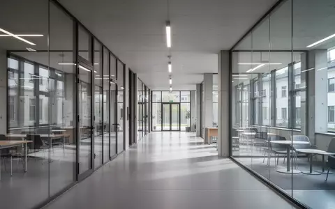 Moderner, leerer Campusflur mit Glasfassade und minimalistischer Architektur am FH OÖ Standort Steyr. - Foto: über boerse-global.de