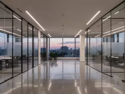 Modernes, minimalistisches Büro-Interieur mit Glaswänden und indirekter Beleuchtung in der Abenddämmerung. - Foto: über boerse-global.de