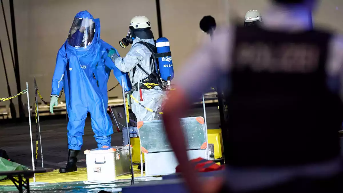 Ein Feuerwehrmann im Chemikalienschutzanzug untersucht nach dem Gefahrgutalarm den geräumten Bereich von Terminal 1 am Flughafen BER. - Bild: Michael Ukas/dpa