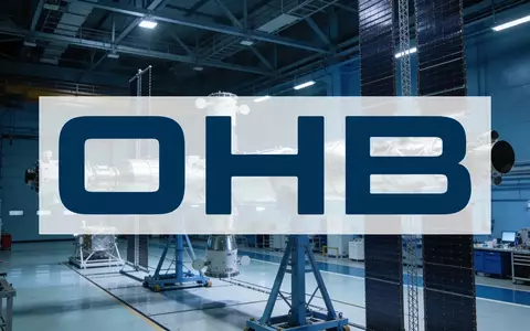 Moderne Raumfahrttechnologie in einer sterilen Montagehalle mit blauer und silberner Beleuchtung. - Foto: über boerse-global.de