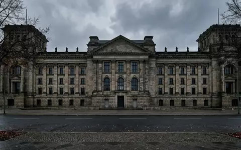 Die steinerne Fassade eines monumentalen Regierungsgebäudes in Berlin unter einem bewölkten Himmel. - Foto: über boerse-global.de