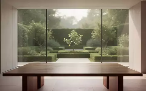 Ein minimalistischer, moderner Innenraum mit sauberer Architektur und natürlichem Licht, das auf einen leeren Holztisch fällt. - Foto: über boerse-global.de