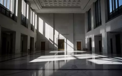 Ein minimalistisches, modernes Regierungsgebäude mit architektonischen Licht- und Schattenmustern auf dem Boden. - Foto: über boerse-global.de