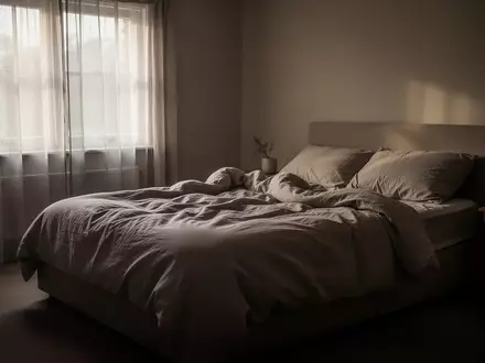 Ein ungemachtes Bett in einem stillen Schlafzimmer bei gedimmtem Morgenlicht, das eine Atmosphäre von Erschöpfung und Einsamkeit vermittelt. - Foto: über boerse-global.de