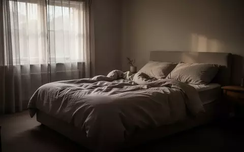 Ein ungemachtes Bett in einem stillen Schlafzimmer bei gedimmtem Morgenlicht, das eine Atmosphäre von Erschöpfung und Einsamkeit vermittelt. - Foto: über boerse-global.de