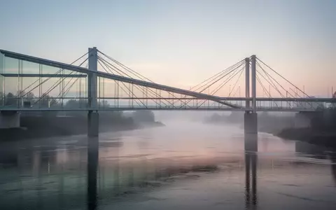 Eine moderne Brücke über einen Fluss im Morgengrauen als Symbol für grenzüberschreitende Zusammenarbeit. - Foto: über boerse-global.de