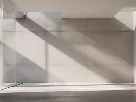 Ein minimalistischer, sonnendurchfluteter Innenraum mit geometrischen Linien und weichen Schatten an einer Betonwand. - Foto: über boerse-global.de