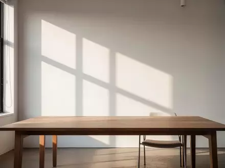 Ein minimalistischer, moderner Arbeitsbereich in einem kreativen Studio mit leerem Holztisch und natürlichem Licht. - Foto: über boerse-global.de